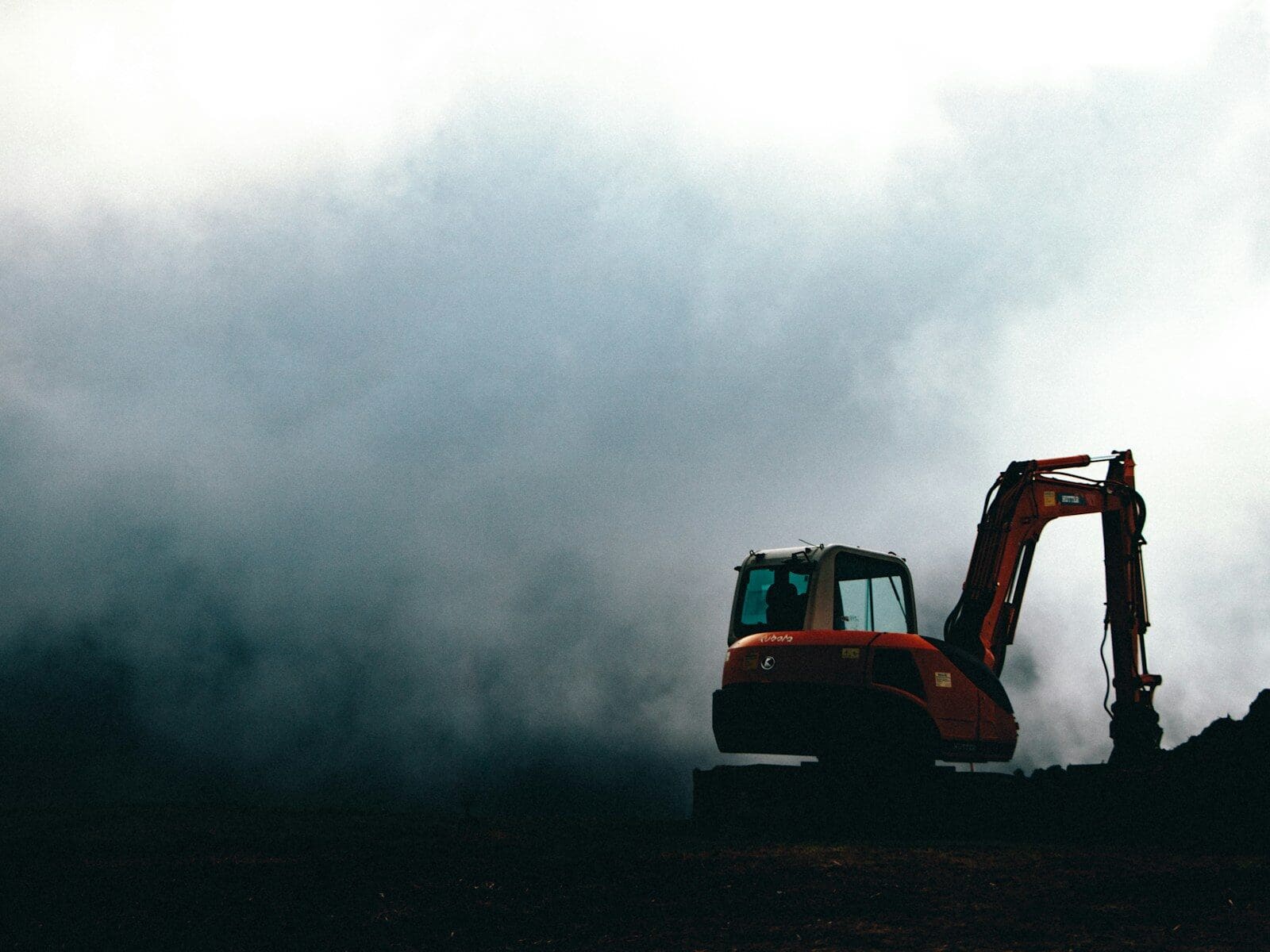a bulldozer in the middle of a field on a cloudy day